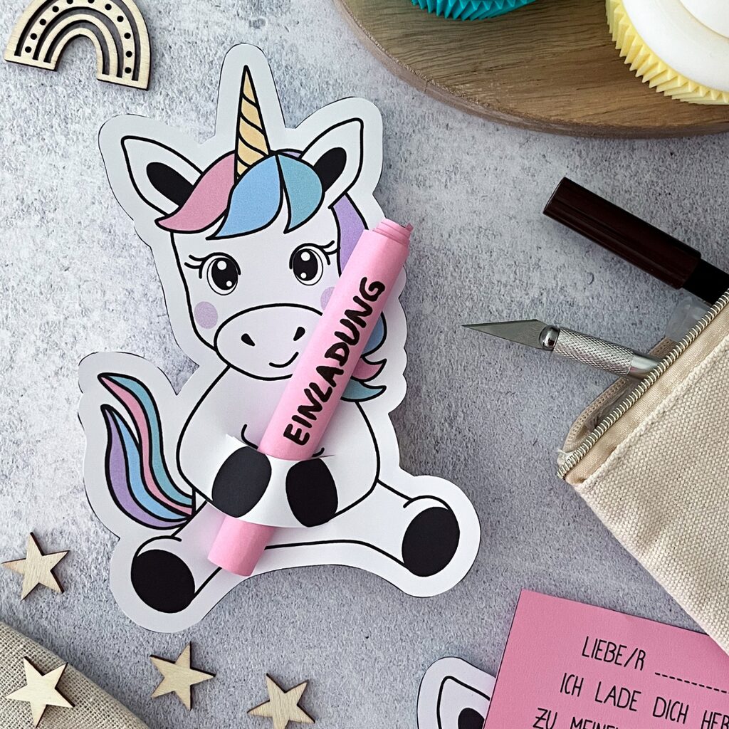 Druckvorlage für eine Einhorn Einladung zum Kindergeburtstag. Das Einhorn hält den Einladungstext in den Händen.